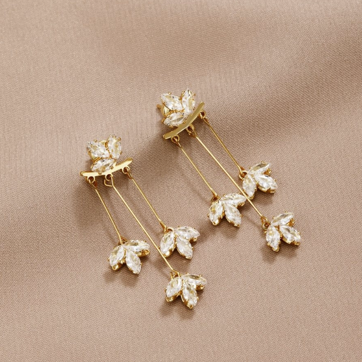 Brincos dourados brilhantes com folhas de cristal cintilantes para um visual elegante