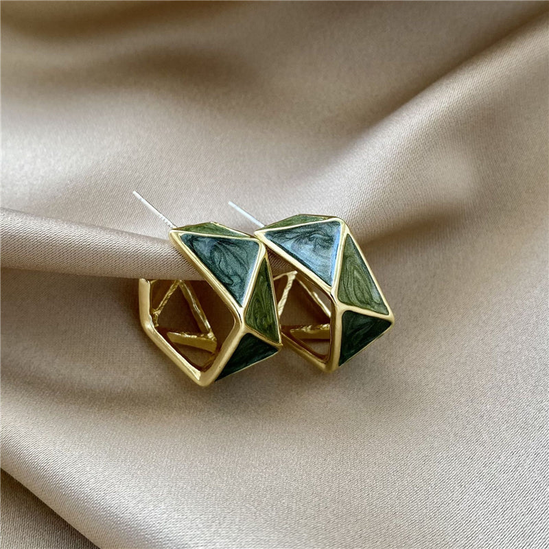 Brincos dourados radiantes com um toque de realce em esmalte verde