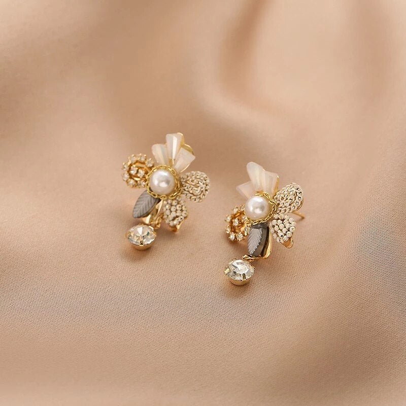 Belíssimos brincos dourados em design floral com pérolas brilhantes