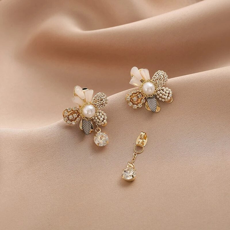 Belíssimos brincos dourados em design floral com pérolas brilhantes