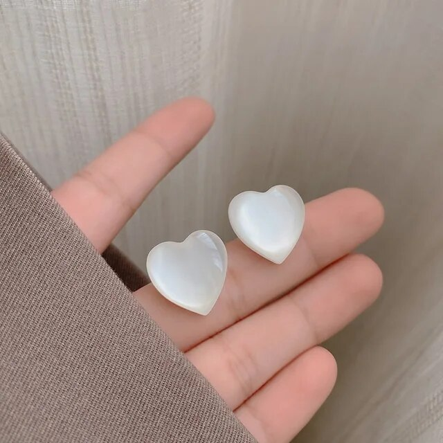 Elegantes brincos com pendentes de coração brancos estilosos