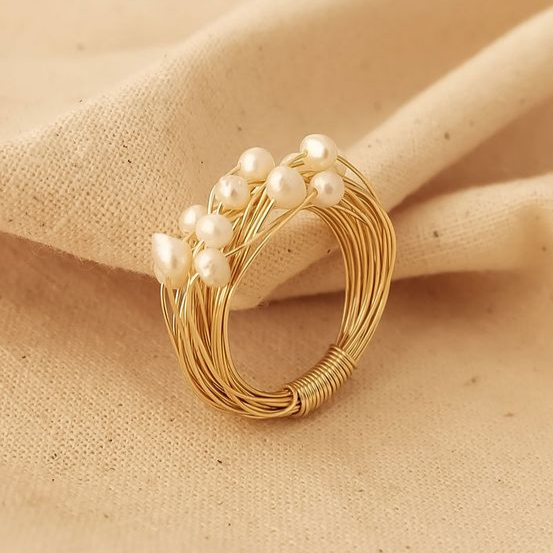 Anel elegante com pérolas brilhantes e delicados detalhes em ouro