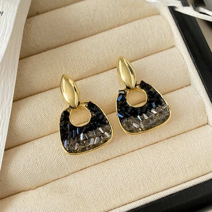 Elegantes brincos de cristal preto cintilante e ouro radiante