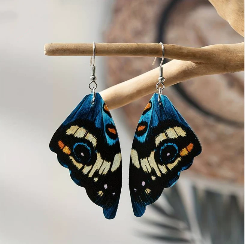 Brilhantes brincos vintage no design de uma asa de borboleta azul
