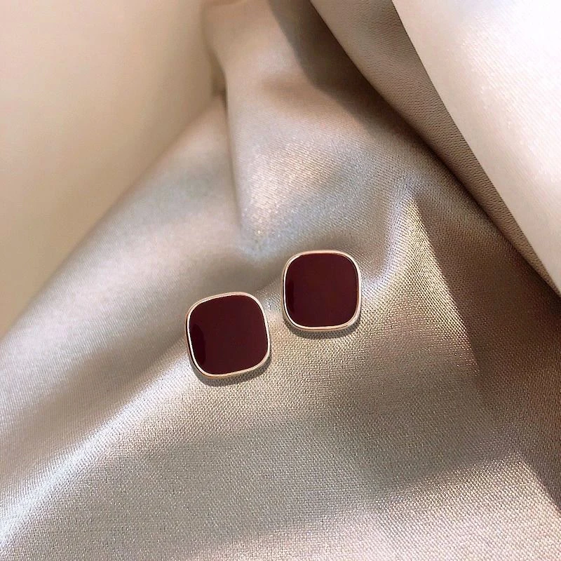 Elegantes brincos de cubo em dourado e vermelho brilhante