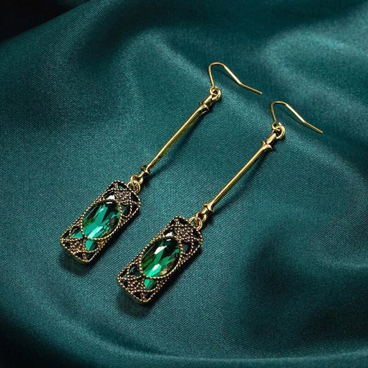 Elegantes brincos dourados com pendente de lanterna verde cintilante