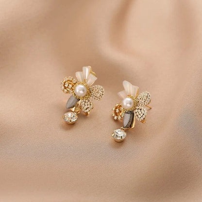 Belíssimos brincos dourados em design floral com pérolas brilhantes