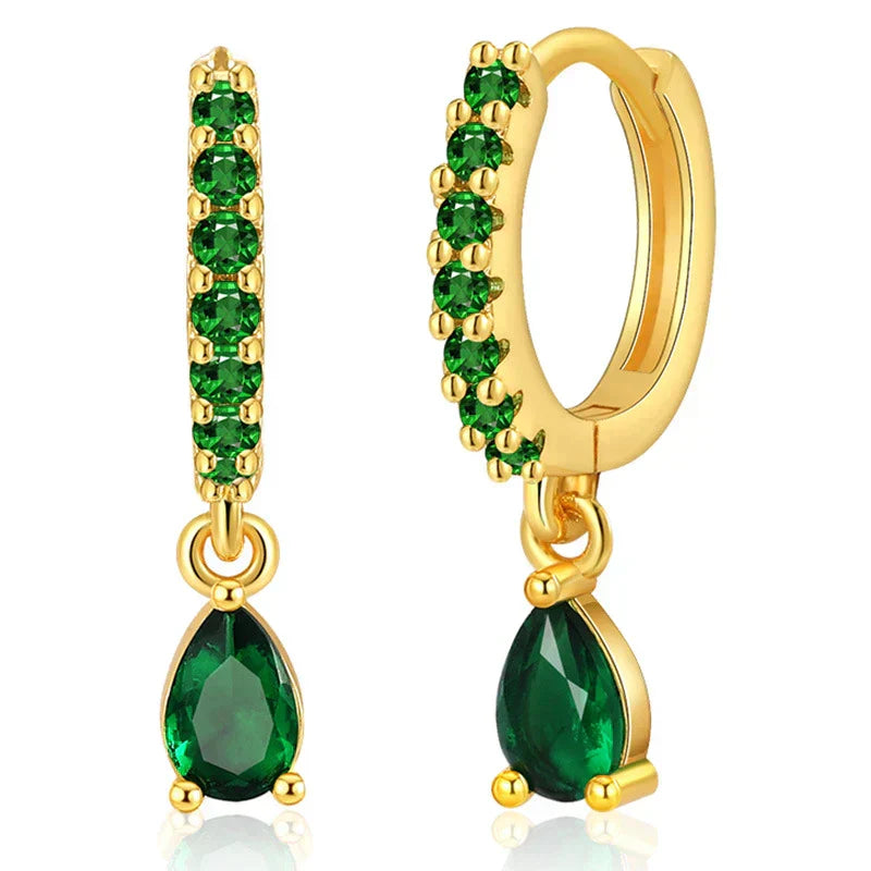 Brilhantes brincos dourados com zircônias cintilantes e uma encantadora esmeralda verde
