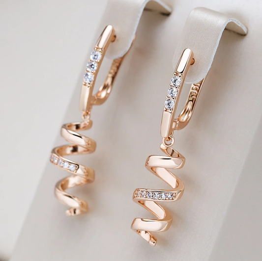 Elegantes brincos de espiral dourados com pedras de zircônia brilhantes