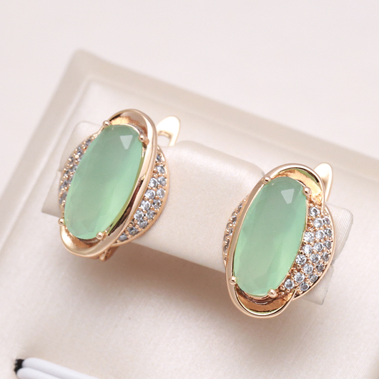Brincos elegantes em ouro com um accentue de cristal verde cintilante